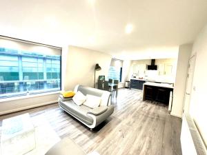 a living room with a couch and a kitchen at Best Location, Luxury, 2 to 8 guest, SkyTV and More in Liverpool