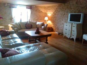 a living room with a couch and a coffee table at la grange in Jeuxey
