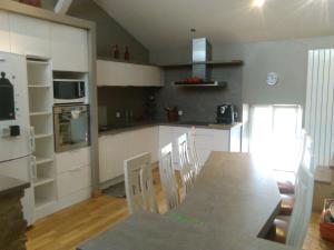 a kitchen with a table and chairs in a room at la grange in Jeuxey