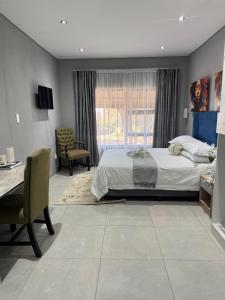 1 dormitorio con 1 cama grande, escritorio y escritorio en GlowtiAirbnb, en Centurion 8 fotos más