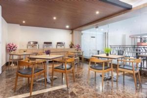 a restaurant with tables and chairs in a room at Life Hotel Soekarno Hatta Makassar in Makassar