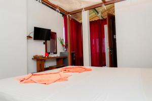 a bedroom with a bed with orange towels on it at Lucky Tuna in Unawatuna