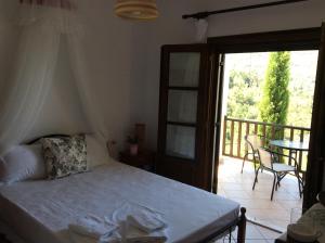 a bedroom with a bed and a balcony with a table at Aspasia's Villa in Prinos