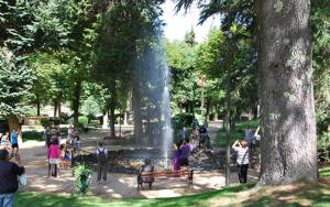 a group of people standing around a fountain in a park at T2 proche Thermes Vals Idéal curistes et familles in Vals-les-Bains +2 photos