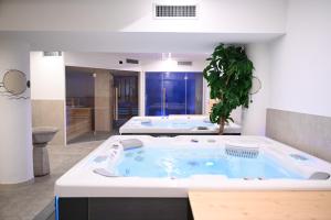 a jacuzzi tub with a plant in a bathroom at Hotel Bellevue in Canazei +51 photos