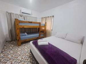 a bedroom with a bed with a purple blanket at Laren Hi'ilani Homes in Apia