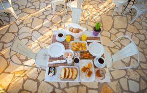 una mesa de picnic con alimentos para el desayuno. en Agathi Apartments en Sivota