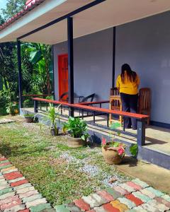 a woman standing on a bench outside of a house at Bung Bud Homestay Kohyaonoi in Phangnga +8 photos