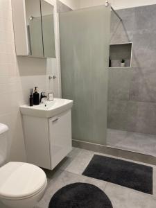 a bathroom with a toilet and a sink and a shower at Atlas suites WEST in Košice