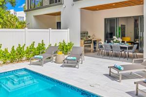 フォート・ローダーデールにあるTownhouse Heated Pool Centrally Located Malibu Keyのパティオ(プール、椅子、テーブル付)