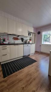 an empty kitchen with white cabinets and a large window at Lumi & Luonto - Private rooms in a 100 sqm 3-BR house with shared common areas in Oulu