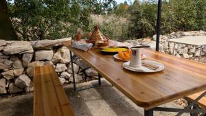 a wooden picnic table with food on top of a stone wall at Le chalet du bien-être in Vailhourles +15 photos