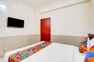 een slaapkamer met een bed en een tv aan de muur bij Via NAR Comforts in Bangalore