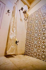 eine Dusche im Bad mit Fliesenboden in der Unterkunft Savita Ba Ni Haveli A Heritage House in Ahmedabad
