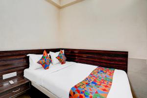 een slaapkamer met een wit bed met een houten hoofdeinde bij Via NAR Comforts in Bangalore +26 foto's
