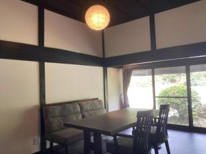 a dining room with a table and chairs and a lamp at fujisakaya藤坂屋 in Tamba-sasayama