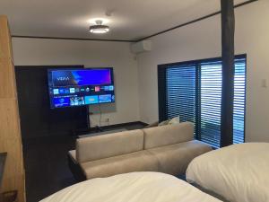 a living room with a couch and a flat screen tv at fujisakaya藤坂屋 in Tamba-sasayama