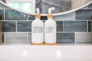 zwei weiße Flaschen auf einer Theke vor einem Spiegel in der Unterkunft H2O Oasis Tree House in Dogwood Acres