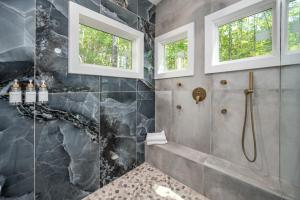 ein Badezimmer mit ebenerdiger Dusche und zwei Fenstern in der Unterkunft H2O Oasis Tree House in Dogwood Acres