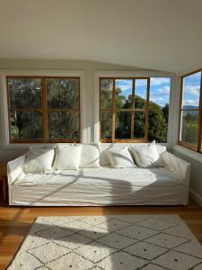 a large white bed in a room with windows at 'Grasmere' in Killora +27 photos