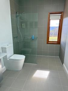 a bathroom with a toilet and a glass shower at 'Grasmere' in Killora