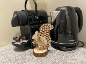 a small figurine of a squirrel next to a coffee maker at Atlas suites WEST in Košice