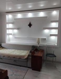 Un dormitorio con una cama, una silla y una mesa. en Mini Hostel, en Bishkek