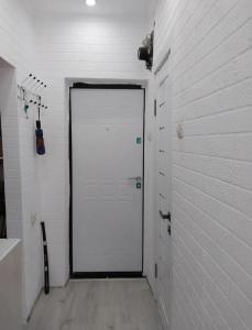 Una puerta blanca en una habitación con una pared de ladrillo blanco. en Mini Hostel, en Bishkek