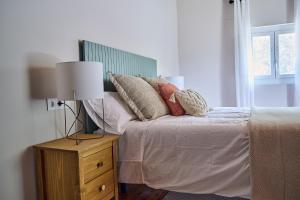 a bed with pillows and a lamp on a night stand at Ojangoiti in Gautegiz Arteaga