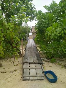 a wooden bridge on the beach with a blue shovel at Seawhip Homestay in Minyaifuin