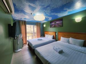 a bedroom with two beds and a ceiling with a sky at Boutique Hote123 in Kuala Lumpur