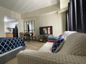 une chambre avec un lit et une télévision à écran plat dans l'établissement Manhattan Plaza Tower 1, Araneta City Cubao, Quezon City, Metro Manila, à Manille