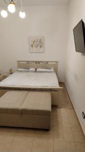 a bedroom with a bed and a flat screen tv at Martina in Santa Maria di Castellabate