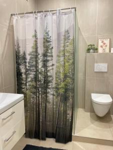 a shower curtain with a picture of trees at Atlas suites EAST in Košice