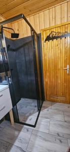 a glass door in a room with a wooden wall at Mój Domek z kominkiem i jacuzzi na wyłączność in Wisła