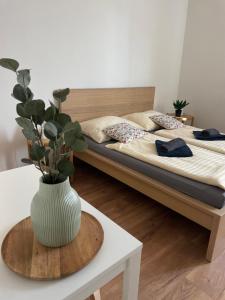 a bedroom with a bed with a vase on a table at Atlas suites EAST in Košice