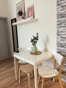 a white dining room table and chairs with a vase on it at Atlas suites EAST in Košice +4 photos