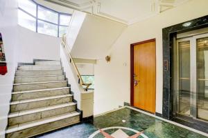 a staircase in a building with a wooden door at FabHotel Ratna Regency in Chinchiwad