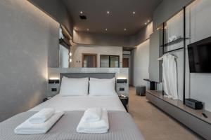 a bedroom with a large bed with two white towels at Amara Luxury Suites With Private Hot Tub in Chania Town