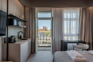 a hotel room with a bed and a kitchen and a balcony at Amara Luxury Suites With Private Hot Tub in Chania Town