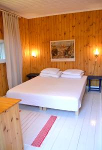 1 dormitorio con 2 camas y paredes de madera en Villa Puharila, en Längelmäki