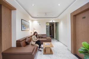 a woman sitting on a couch in a waiting room at Hotel 7 Star I in Surat