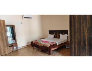 a bedroom with a bed and a mirror at Shree Ram Swaroop vatika, Chitrakoot Dham in Karwi