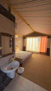 a bathroom with a sink and a bed in a room at Quiet Night Camp Rum in Wadi Rum +55 photos