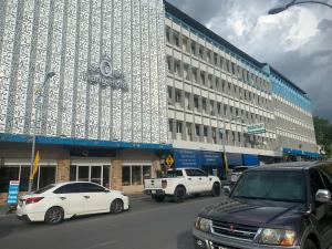 a large white building with cars parked in front of it at S2S Queen Trang Hotel in Trang