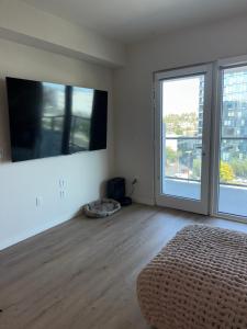 ein weißes Zimmer mit einem Bett und einem großen Fenster in der Unterkunft Elevated Escape Luxury 1BR in Hollywood in Los Angeles