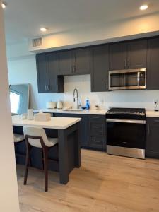eine Küche mit schwarzen Schränken, einem Tisch und einem Waschbecken in der Unterkunft Elevated Escape Luxury 1BR in Hollywood in Los Angeles