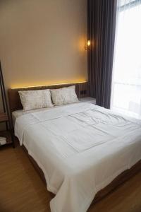 a large white bed in a bedroom with a window at Villa DeValley A9 Batu in Tlekung