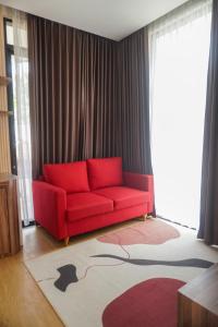 a red couch in a living room with a rug at Villa DeValley A9 Batu in Tlekung