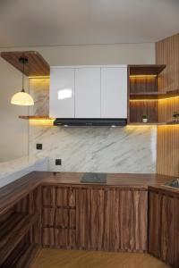 a kitchen with wooden cabinets and a marble counter top at Villa DeValley A9 Batu in Tlekung
